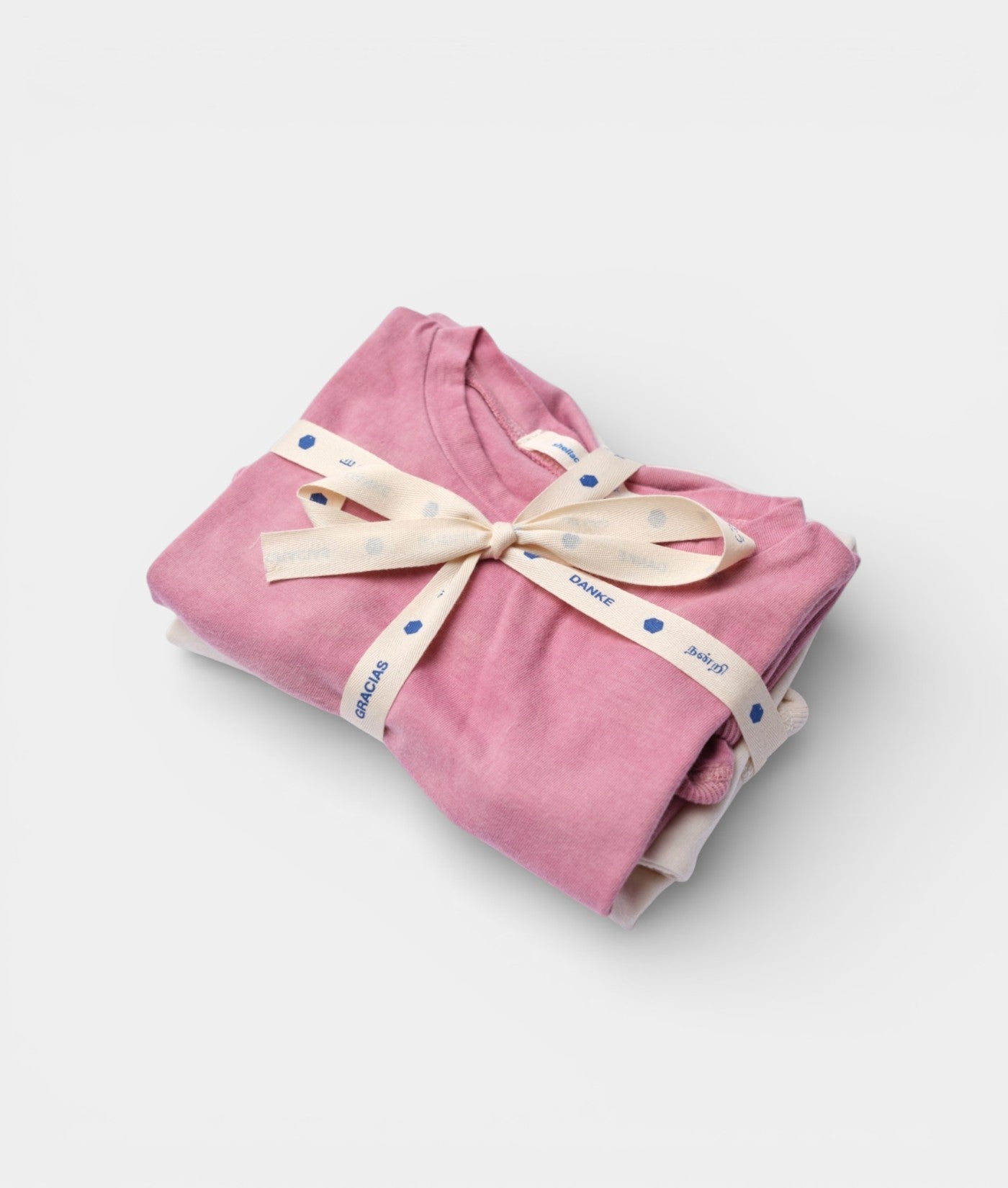 Pink cotton hooded sweatshirt wrapped in polka dot ribbon and tied with a bow, displayed as a flat lay - Industry of All Nations