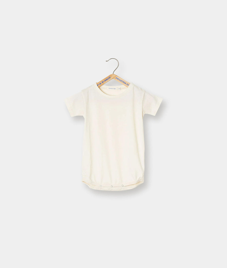 A plain, cream-colored onesie or bodysuit hanging on a hanger - Industry of All Nations