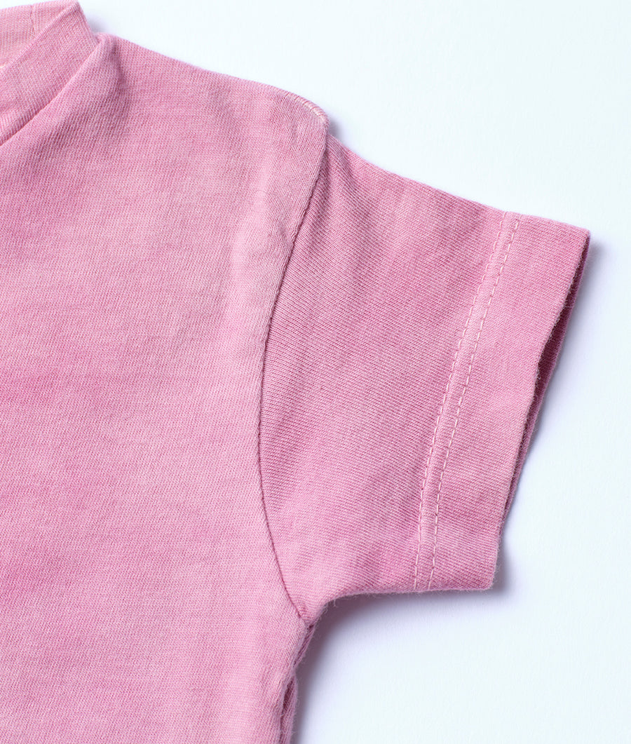 Close-up shot of a pink turtleneck sweater laid flat - Industry of All Nations
