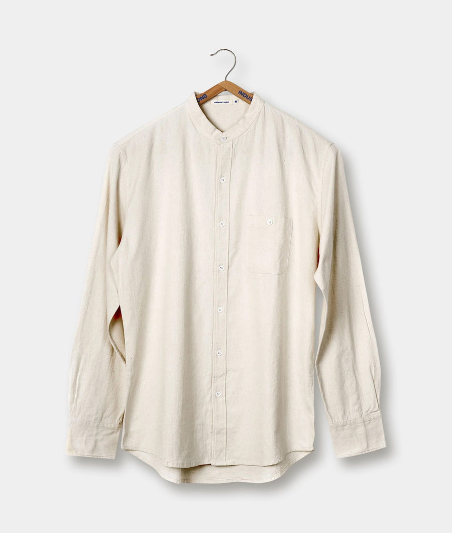 Cream-colored button-down shirt hanging on a wooden hanger - Industry of All Nations