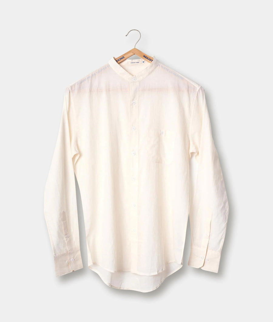A cream-colored button-up shirt hanging on a wooden hanger - Industry of All Nations
