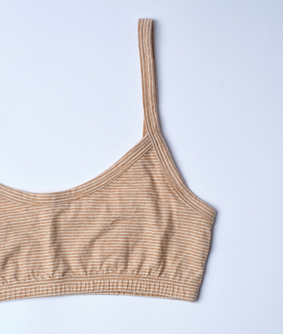 Tan and white striped organic cotton sports bra, displayed in a flat lay on a light blue background - Industry of All Nations
