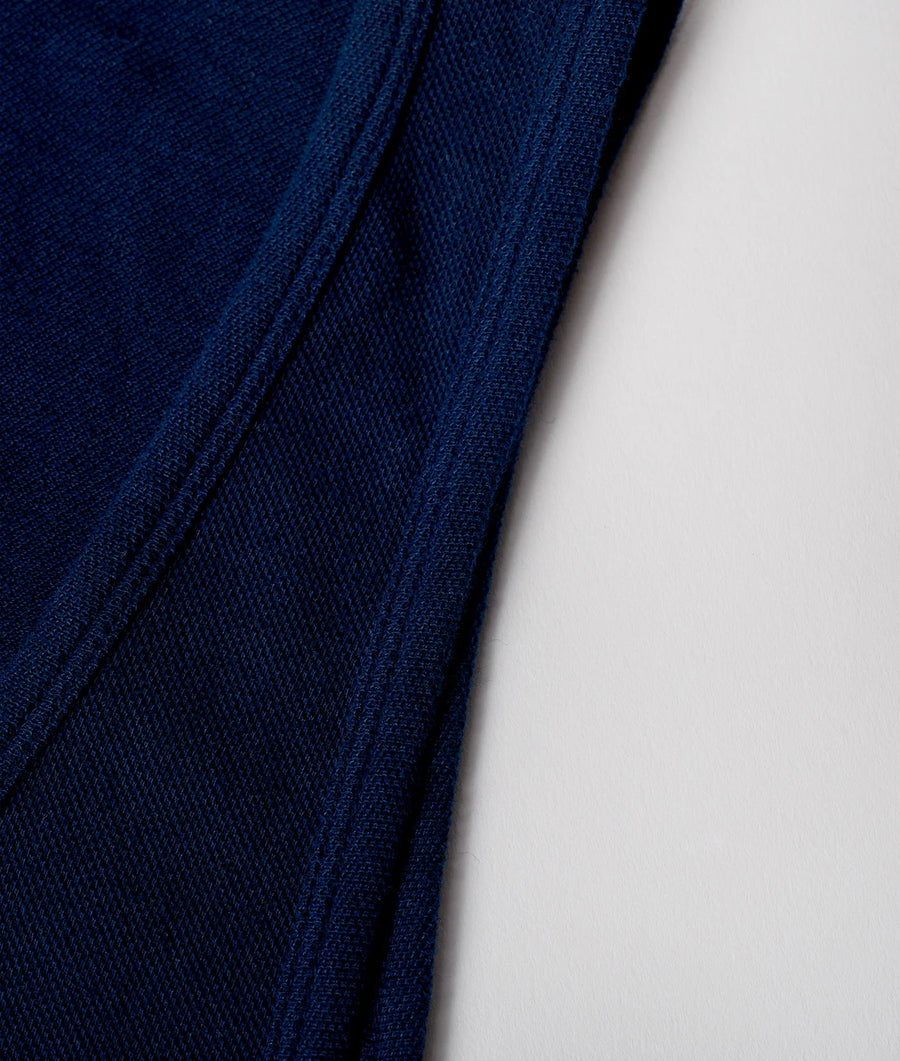 A close-up detail shot of a dark navy blue cotton fabric with a textured weave pattern - Industry of All Nations