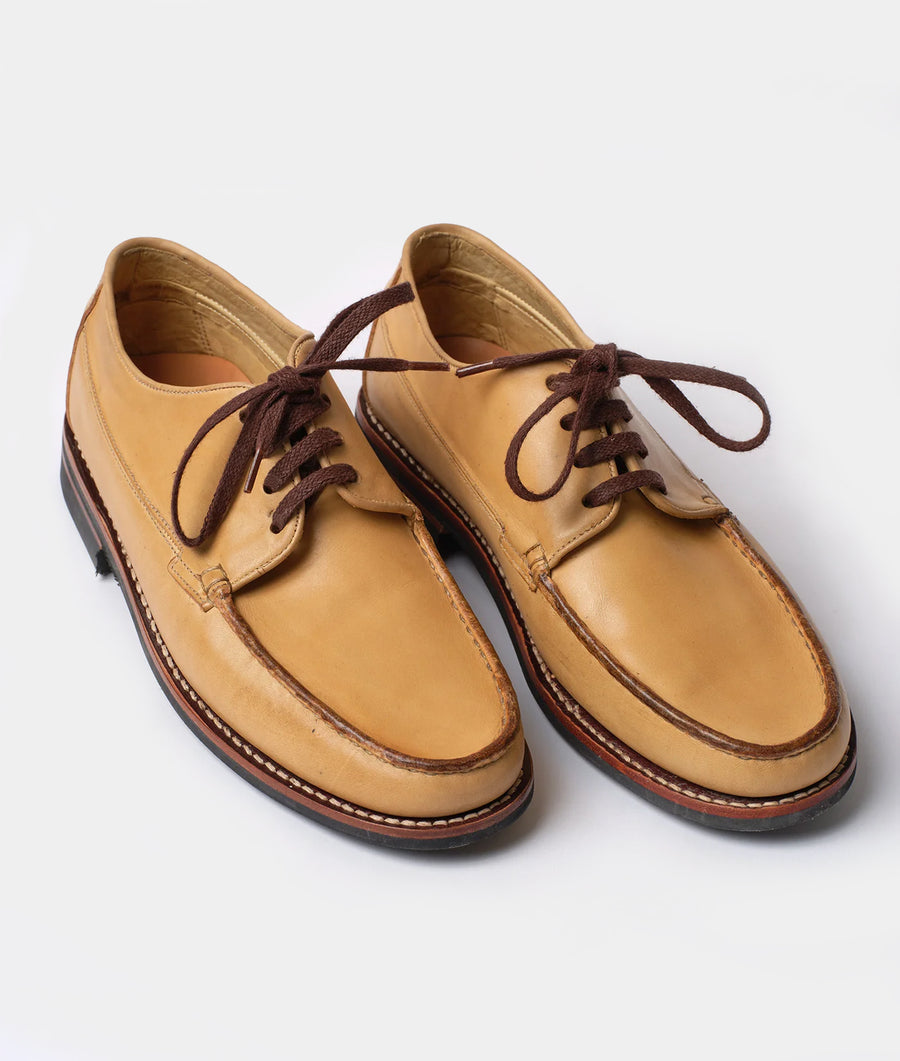 A pair of tan leather oxfords with brown laces, displayed in a flat lay on a white background - Industry of All Nations