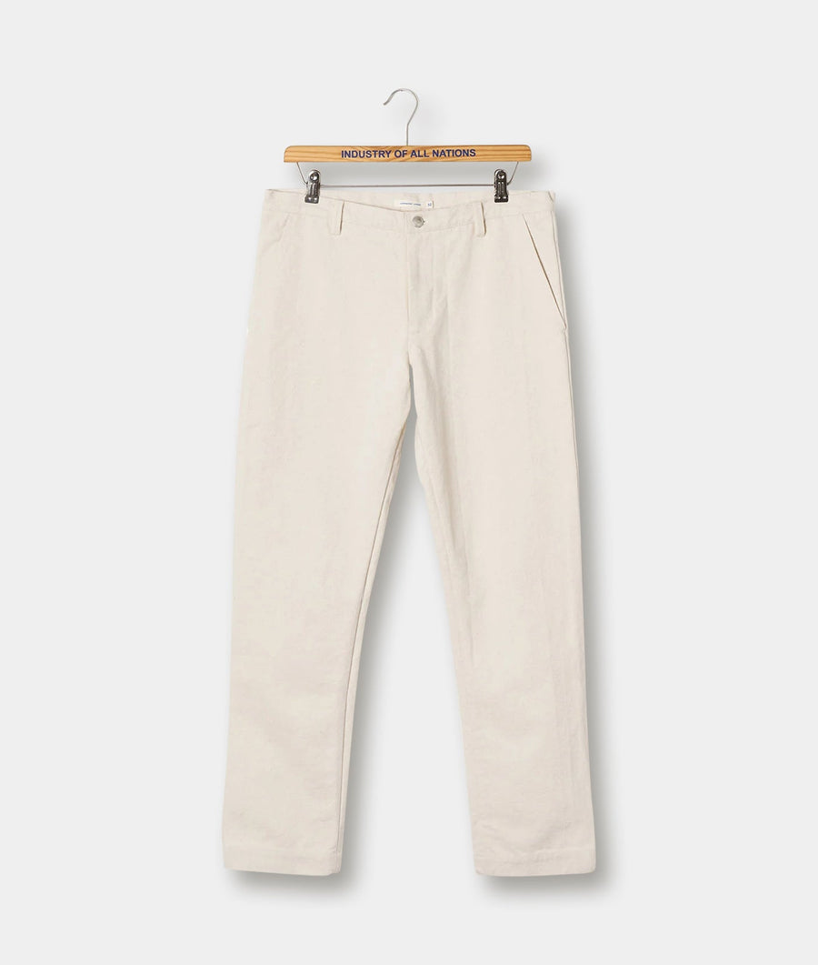 Cream-colored cotton pants displayed on a wooden hanger with "Industry of All Nations" text - Industry of All Nations