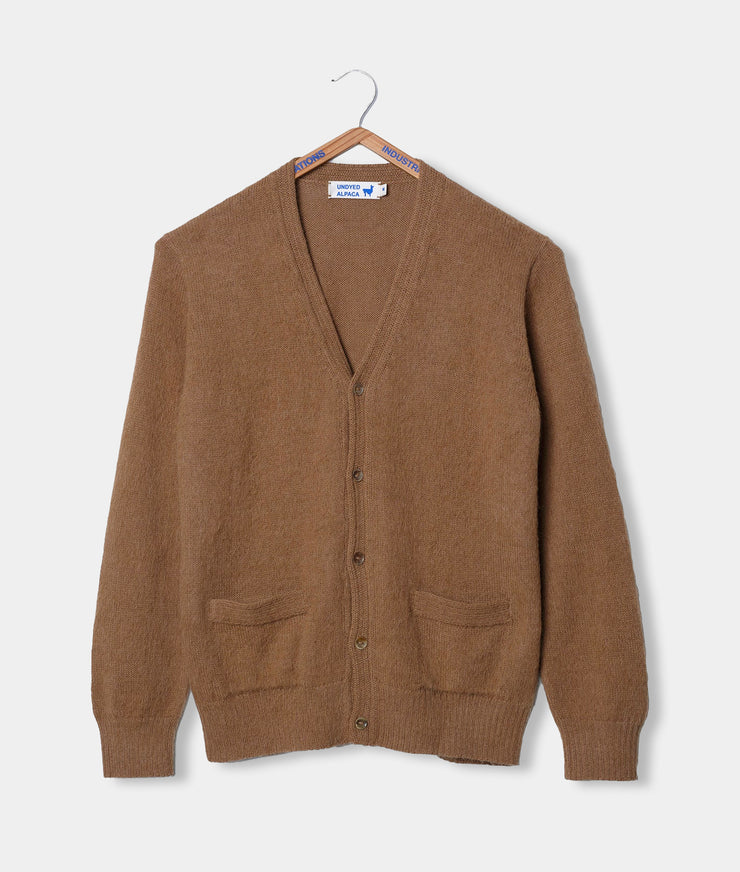 Brown cardigan on a hanger against a gray background