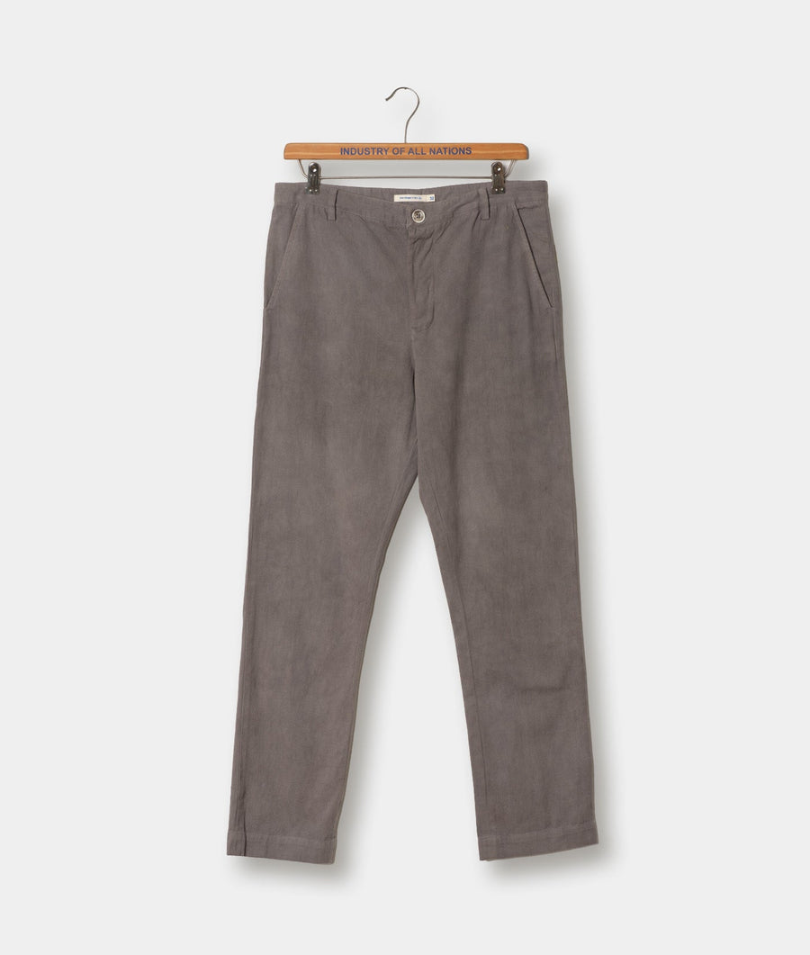Gray cotton trousers hanging on a wooden hanger with 'Industry of All Nations' branding - Industry of All Nations