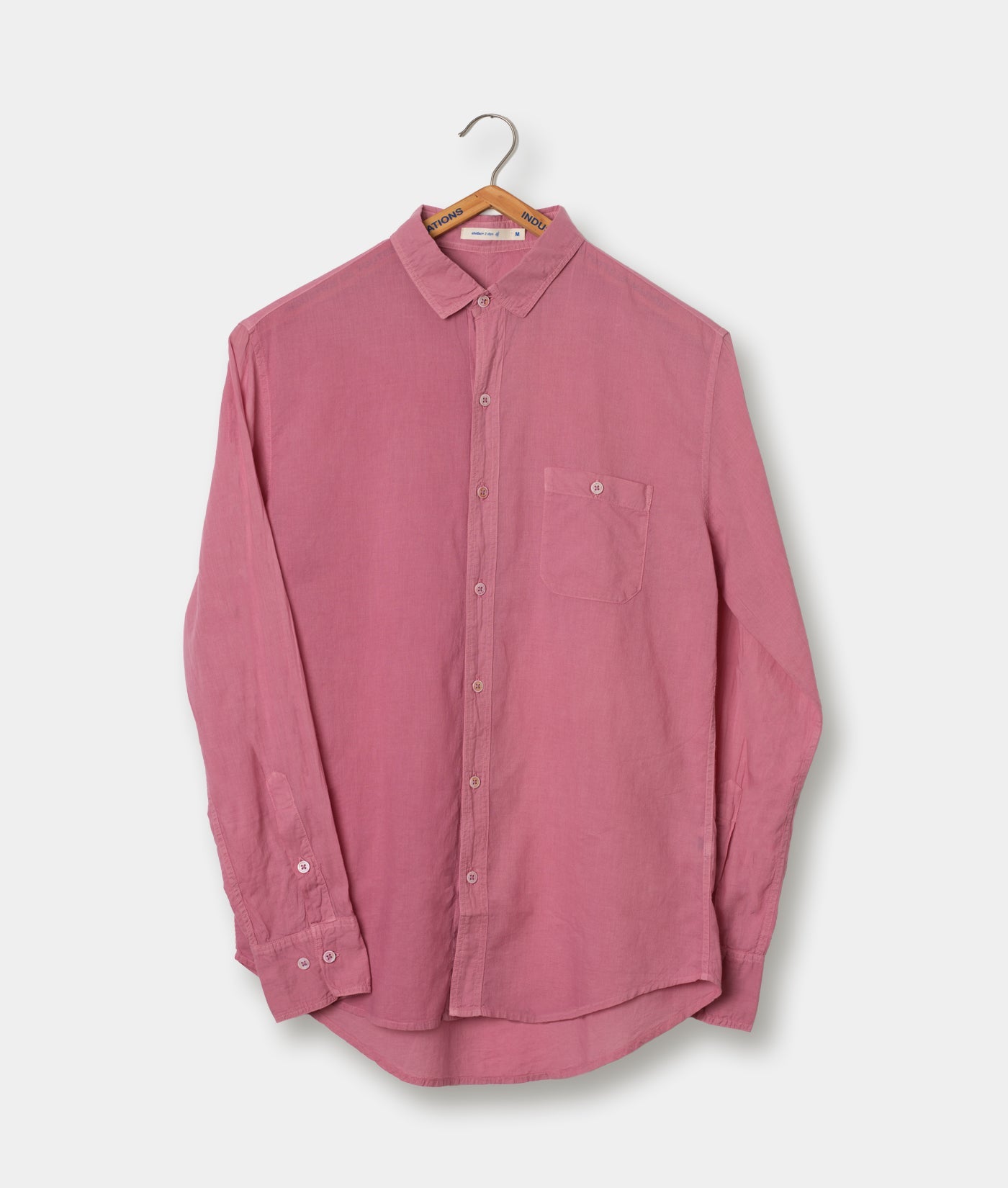 Pink long-sleeved button-down shirt hanging on a hanger against a white background - Industry of All Nations