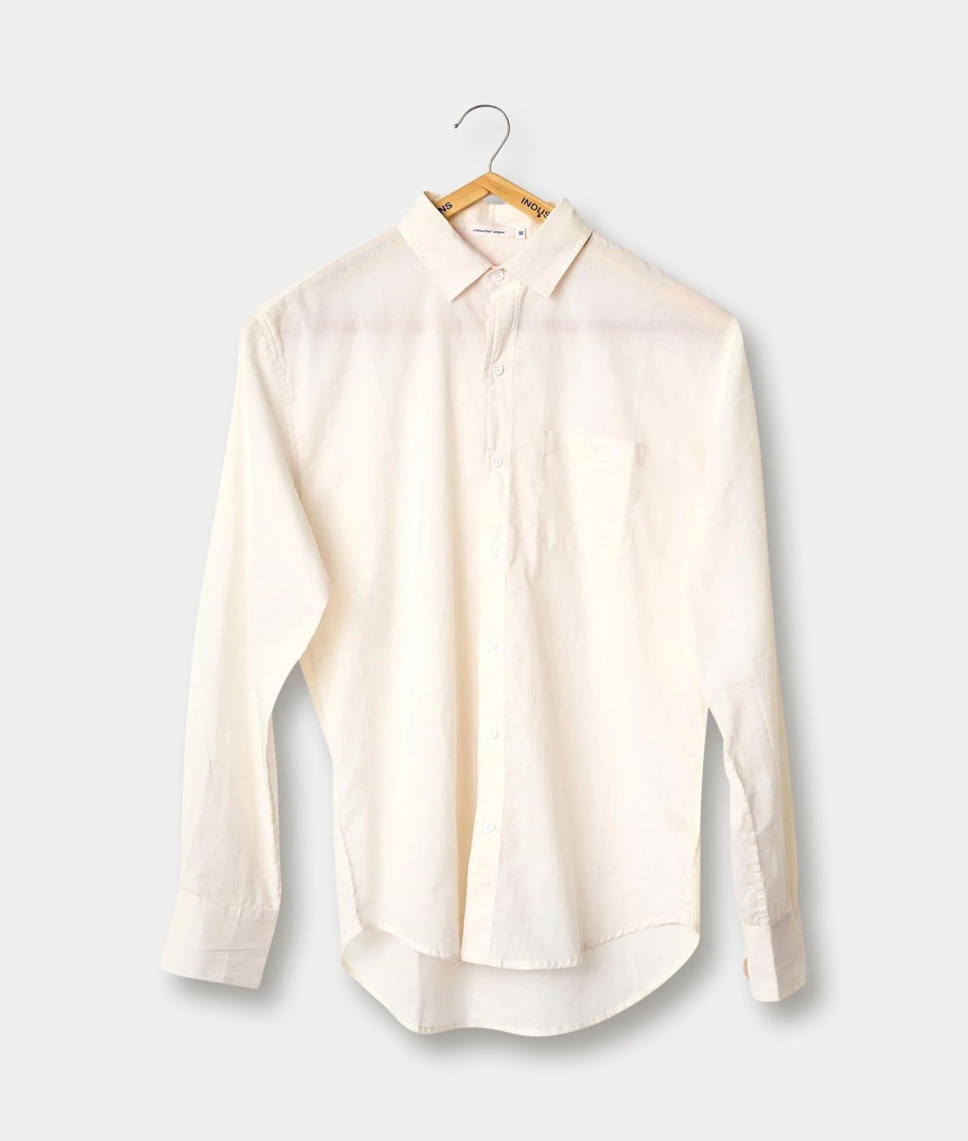 A white button-down shirt displayed on a hanger against a plain background - Industry of All Nations