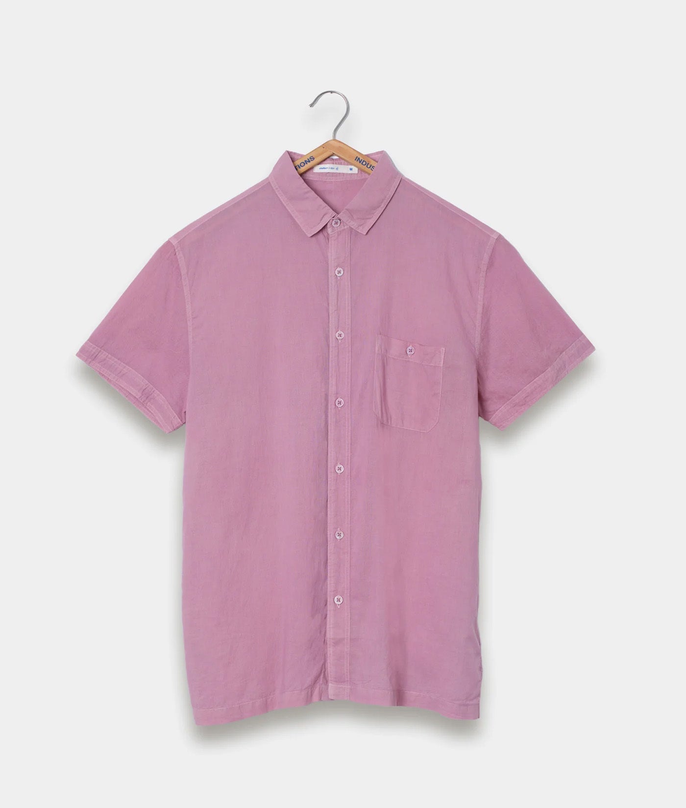 A pink short-sleeved button-up shirt displayed on a hanger - Industry of All Nations