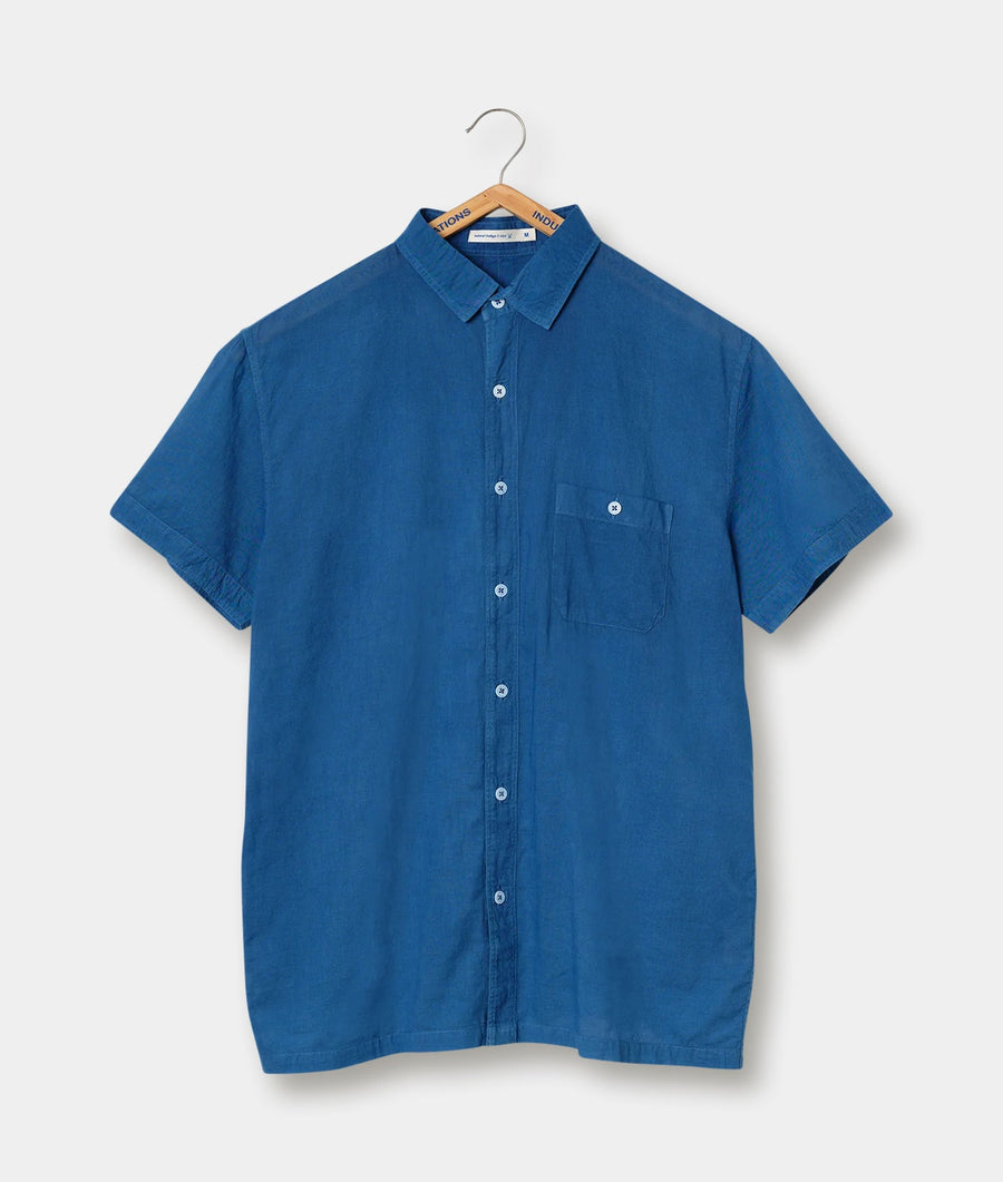 A blue button-down short-sleeve shirt displayed on a wooden hanger - Industry of All Nations