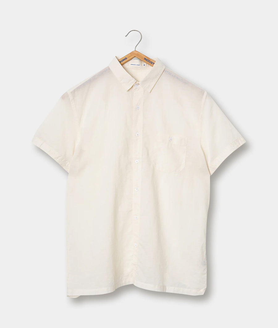 Cream-colored button-down shirt, hung on a wooden hanger against a plain background - Industry of All Nations