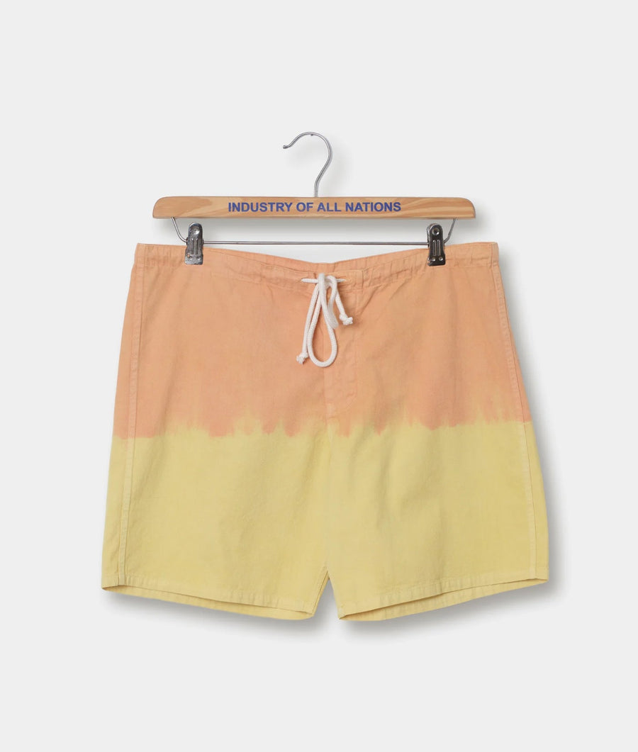 Orange and yellow gradient swimming shorts hanging from a wooden hanger with the text "INDUSTRY OF ALL NATIONS" - Industry of All Nations