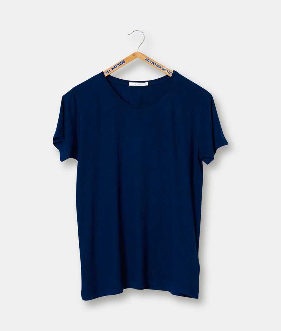 A navy blue short sleeve t-shirt hanging on a wooden hanger with the "All Nations" tag - Industry of All Nations