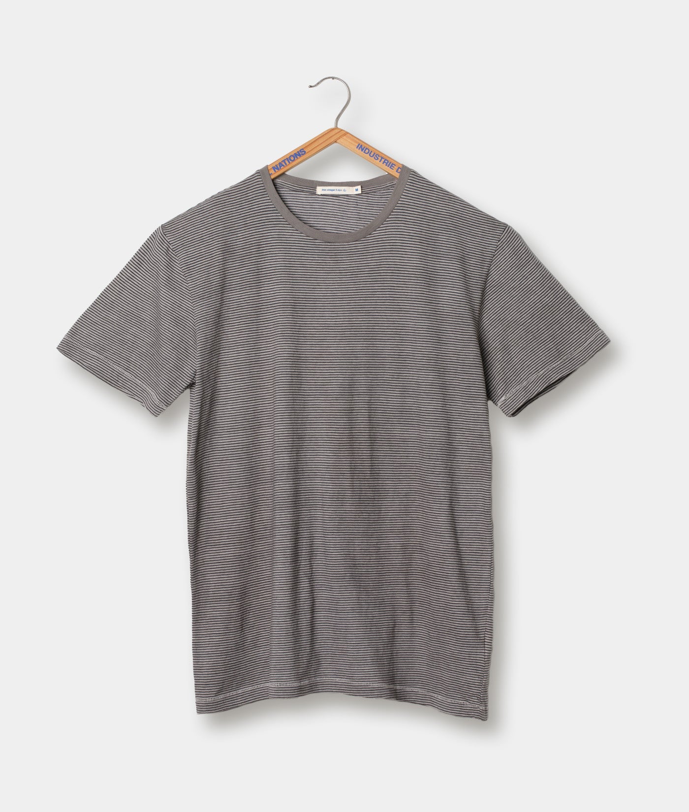 Gray striped short-sleeve t-shirt displayed on a wooden hanger - Industry of All Nations