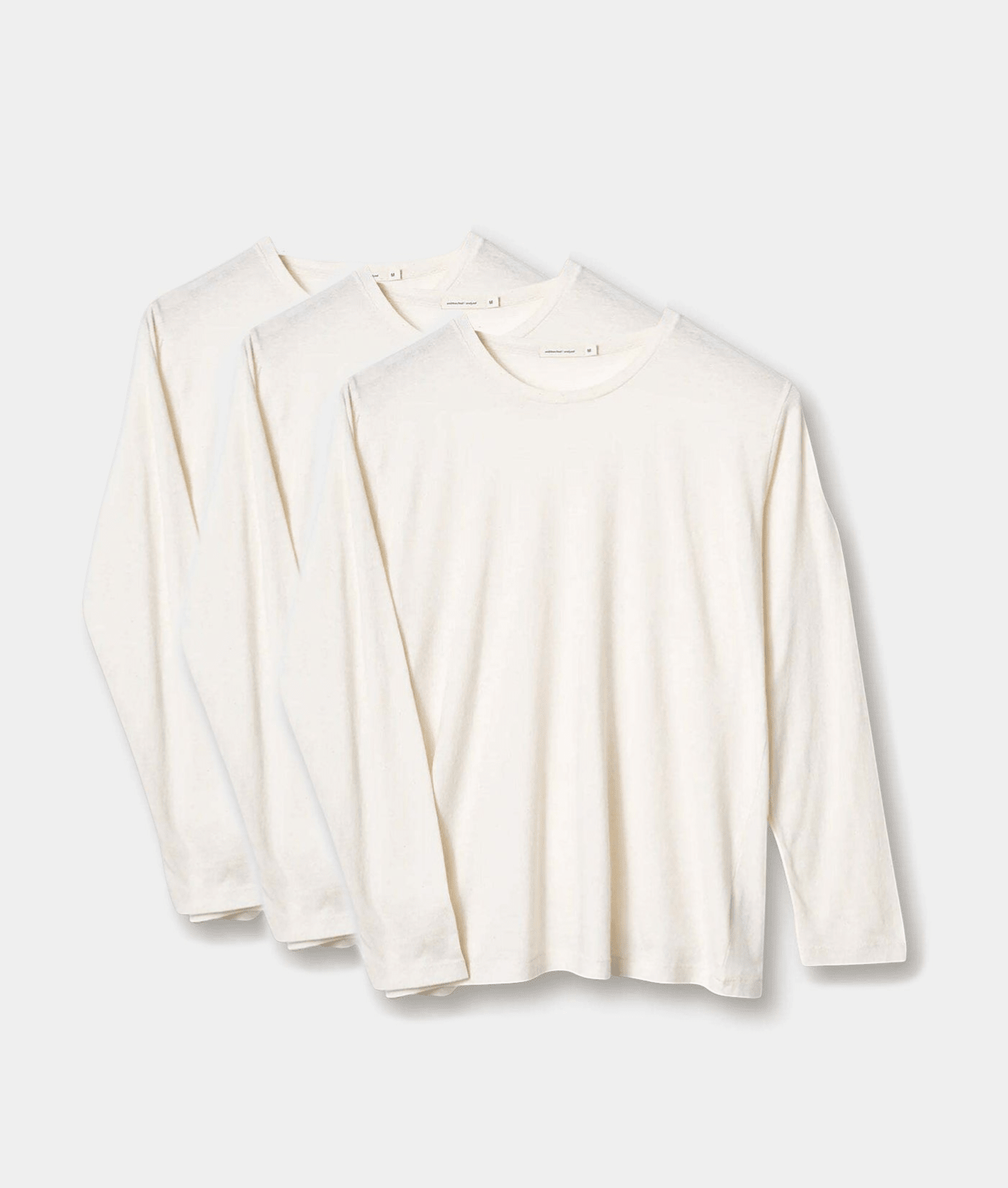 Three white long-sleeve organic cotton t-shirts displayed in a flat lay arrangement - Industry of All Nations