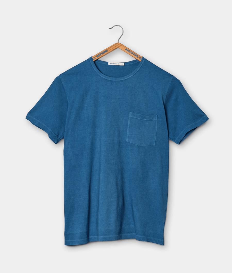 Blue cotton t-shirt with a chest pocket, displayed on a hanger - Industry of All Nations