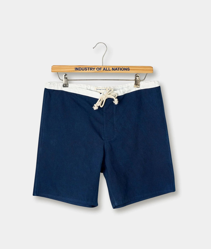 Navy blue drawstring shorts displayed on a wooden hanger with "Industry of All Nations" text - Industry of All Nations