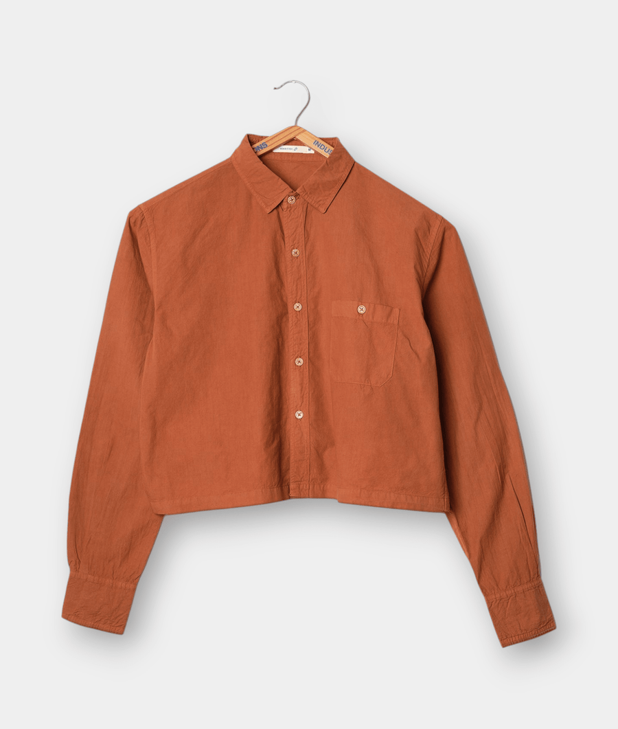 A cropped orange button-down shirt displayed on a hanger - Industry of All Nations