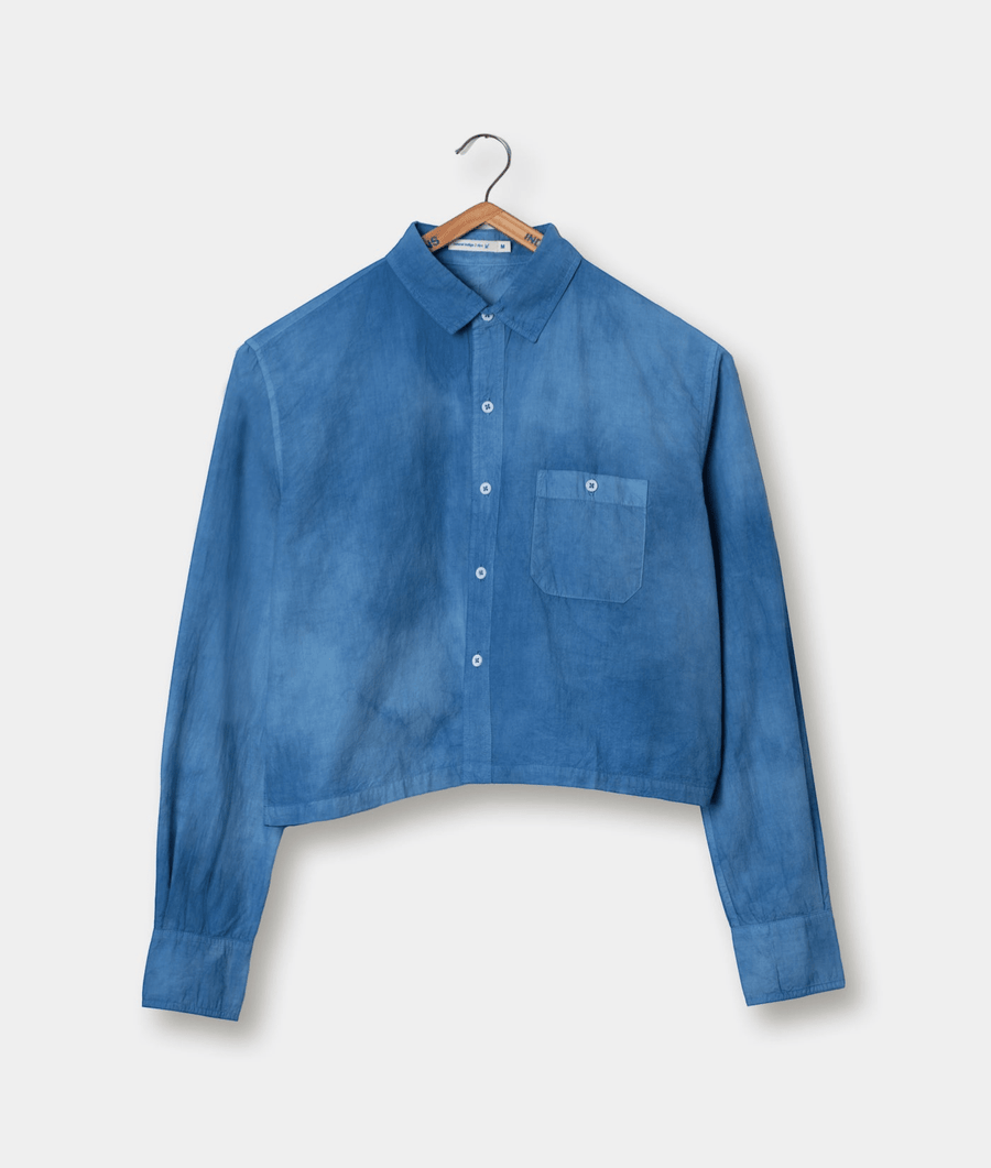 Blue denim collared shirt hanging on a wooden hanger - Industry of All Nations