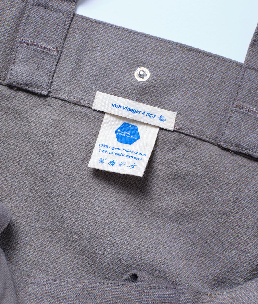 A gray organic cotton garment with a label showing 100% organic Indian cotton and natural Indian dyes - Industry of All Nations.