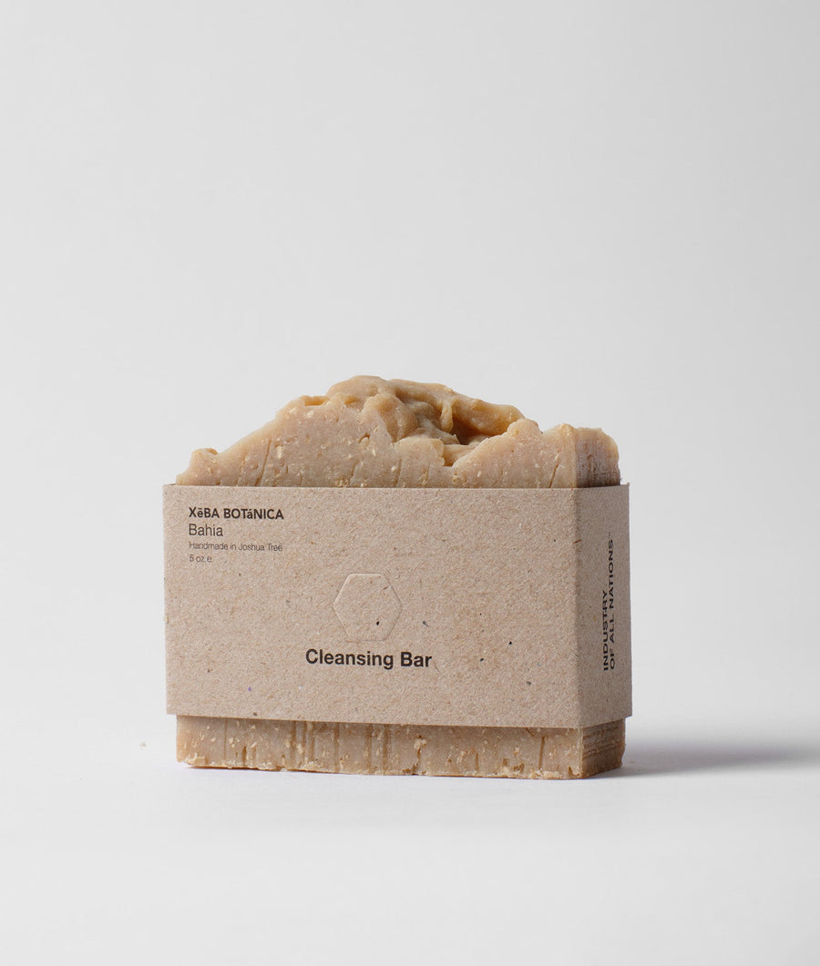 A beige soap bar with the text "Cleansing Bar" printed on the packaging, displayed on a plain white background - Industry of All Nations