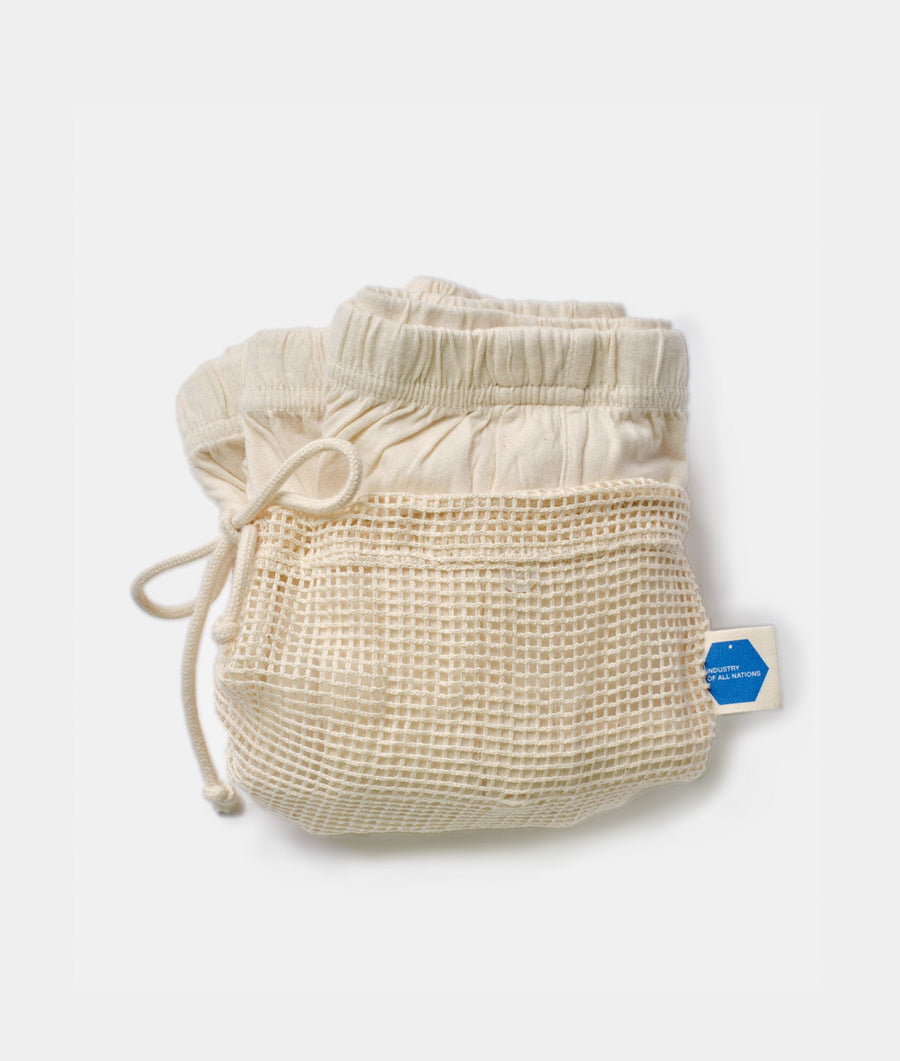 Cream-colored, drawstring-waist shorts made of organic cotton mesh material displayed on a white background - Industry of All Nations