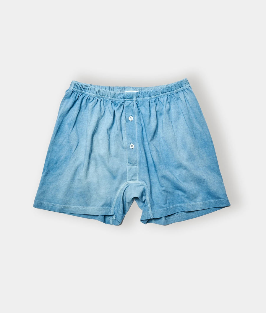 A pair of light blue chambray boxers or shorts displayed in a flat lay arrangement - Industry of All Nations