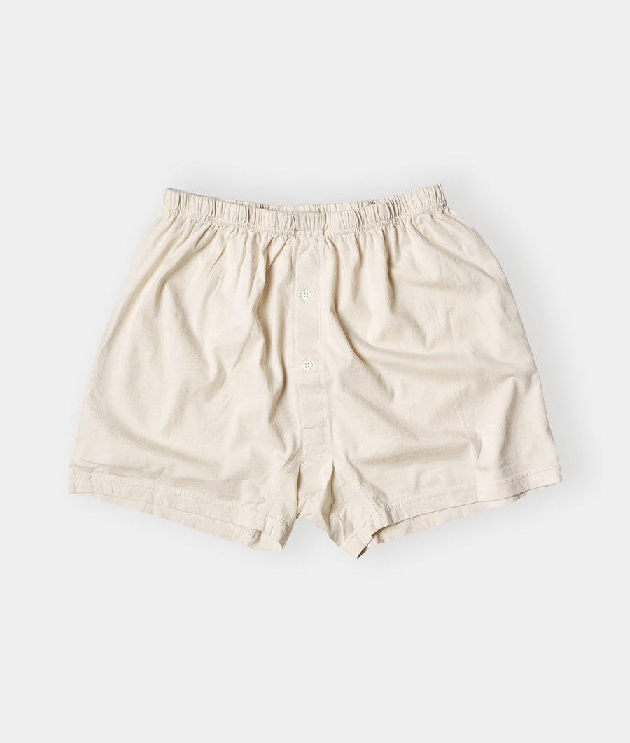 Cream-colored, elastic-waist cotton boxer shorts displayed in a flat lay shot - Industry of All Nations