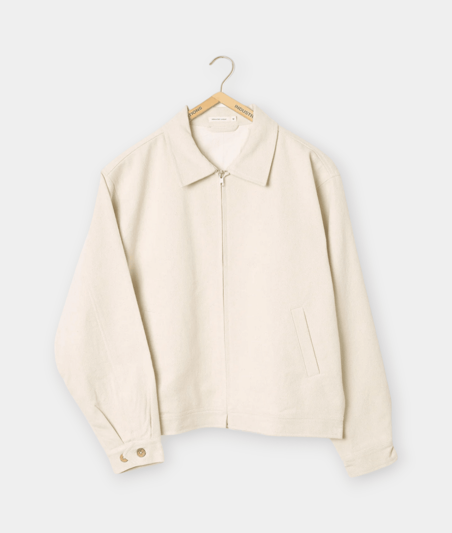 Cream-colored zip-up jacket displayed on a hanger - Industry of All Nations