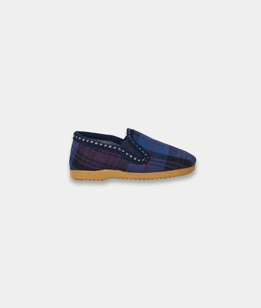 A navy and purple plaid slip-on shoe with a tan rubber sole, displayed on a white background - Industry of All Nations