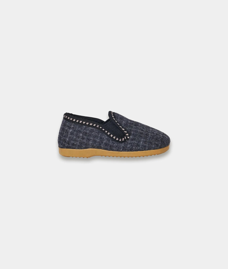 Charcoal grey felt slip-on shoe with black trim detail and beige outsole, displayed on a flat surface - Industry of All Nations