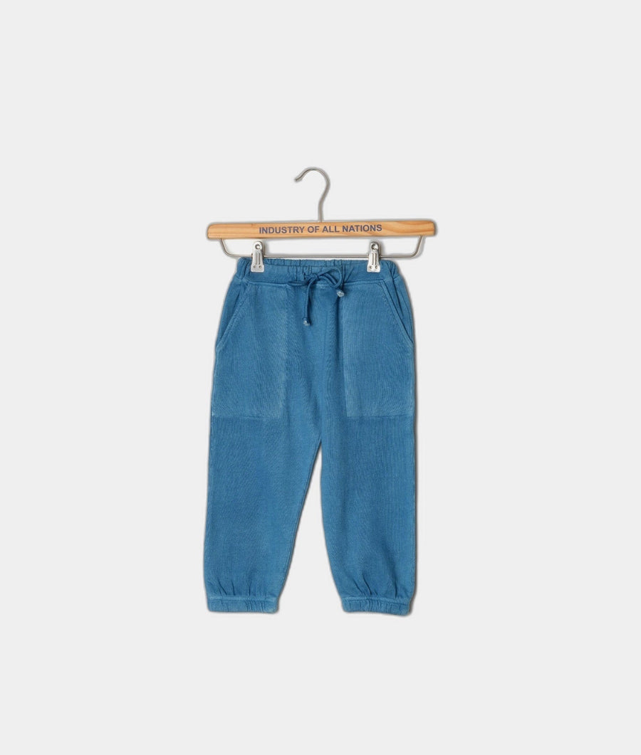 Blue drawstring corduroy pants displayed on a wooden hanger with 'Industry of All Nations' text - Industry of All Nations