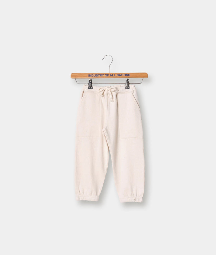 Cream-colored sweatpants with a drawstring waistband, displayed on a wooden hanger with the brand name "Industry of All Nations" printed on it. - Industry of All Nations