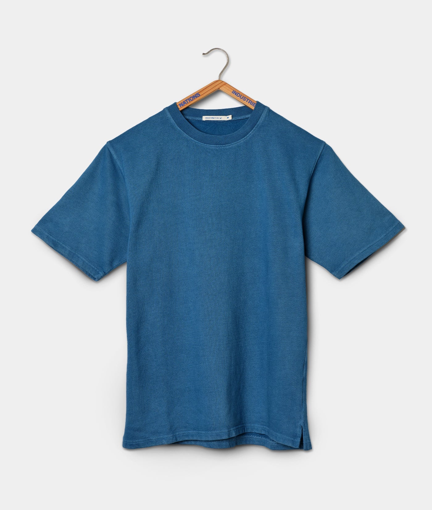 A blue tee shirt hanging on a wooden hanger - Industry of All Nations