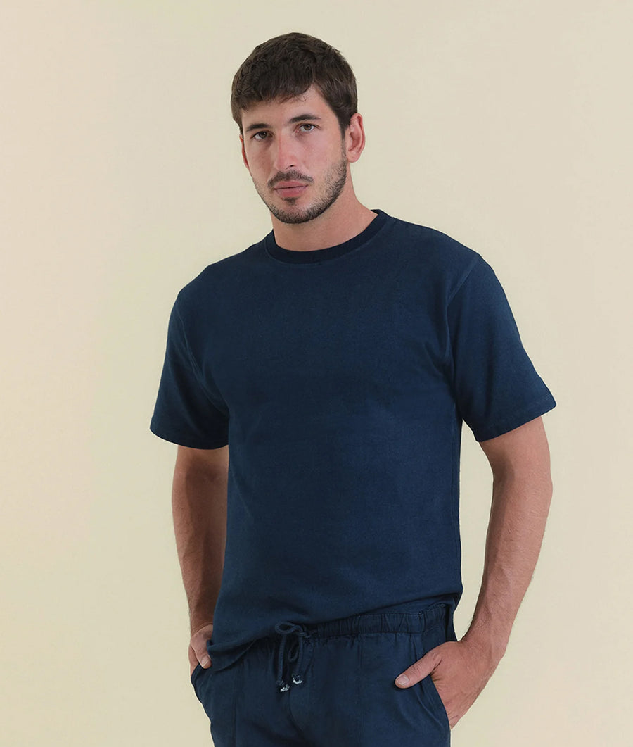 A young man wearing a navy blue short-sleeved t-shirt - Industry of All Nations