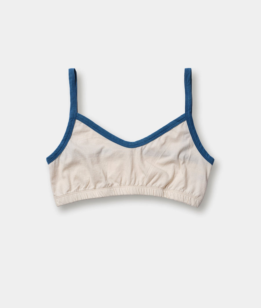 Beige bra-style crop top with navy blue trim, displayed flat against a plain white background - Industry of All Nations