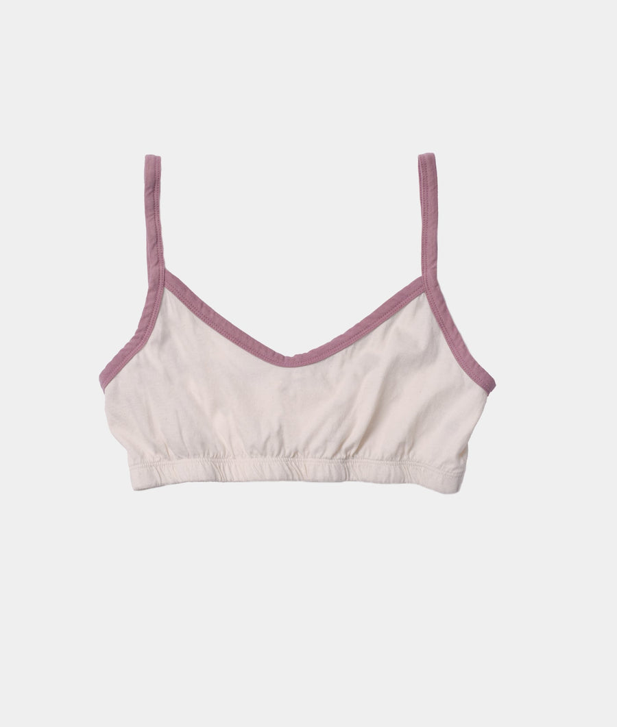 Cream-colored sports bra with pink trim, displayed against a white background - Industry of All Nations