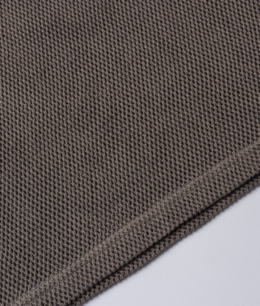 Detailed close-up shot of a charcoal gray knitted fabric texture in a flat lay configuration - Industry of All Nations