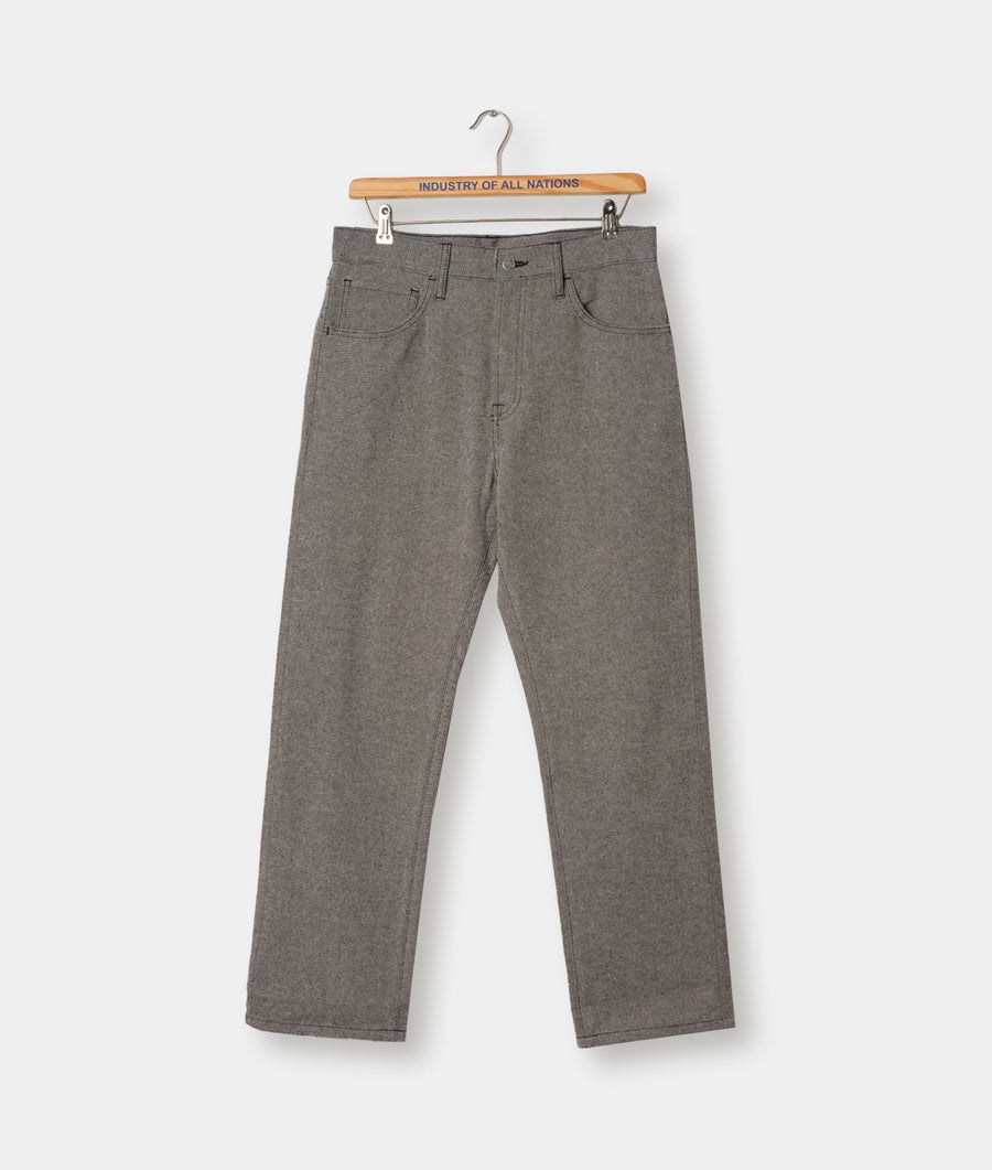 Gray-colored jeans or pants hanging on a wooden hanger with the brand name "Industry of All Nations" printed on it - Industry of All Nations