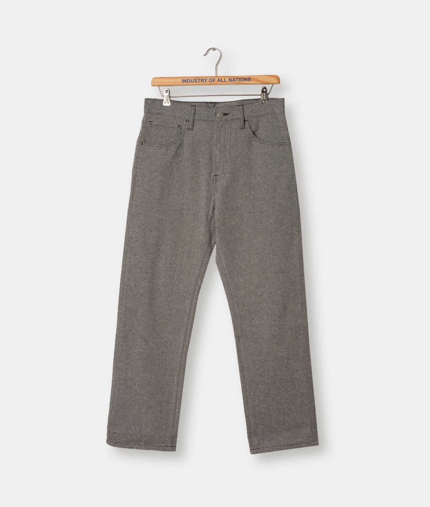 Gray-colored jeans or pants hanging on a wooden hanger with the brand name "Industry of All Nations" printed on it - Industry of All Nations