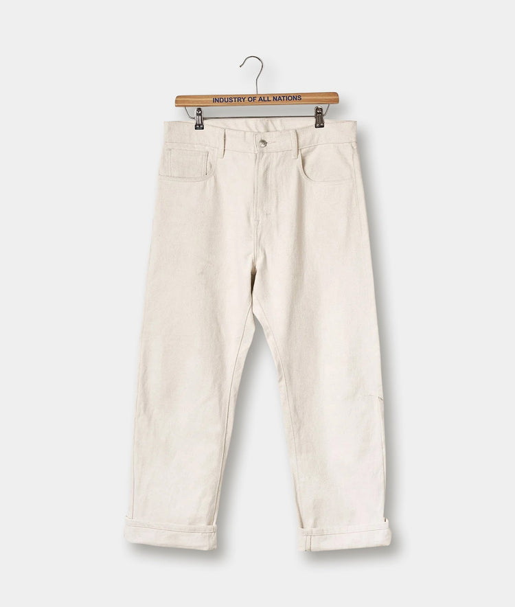 Cream-colored denim pants displayed on a wooden hanger with the brand name "Industry of All Nations" printed on the hanger - Industry of All Nations — Coco / 26