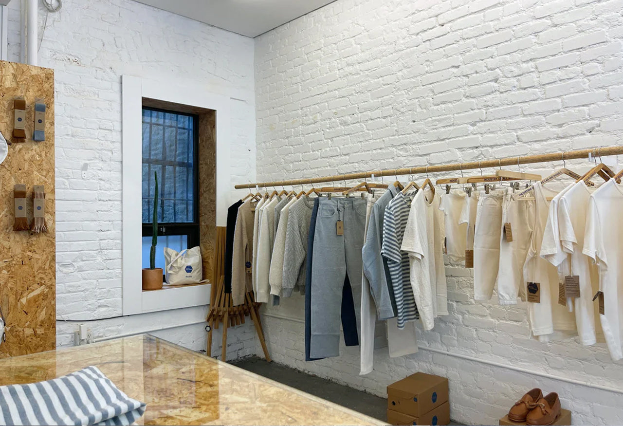 Clothing store interior with garment rack and painted brick