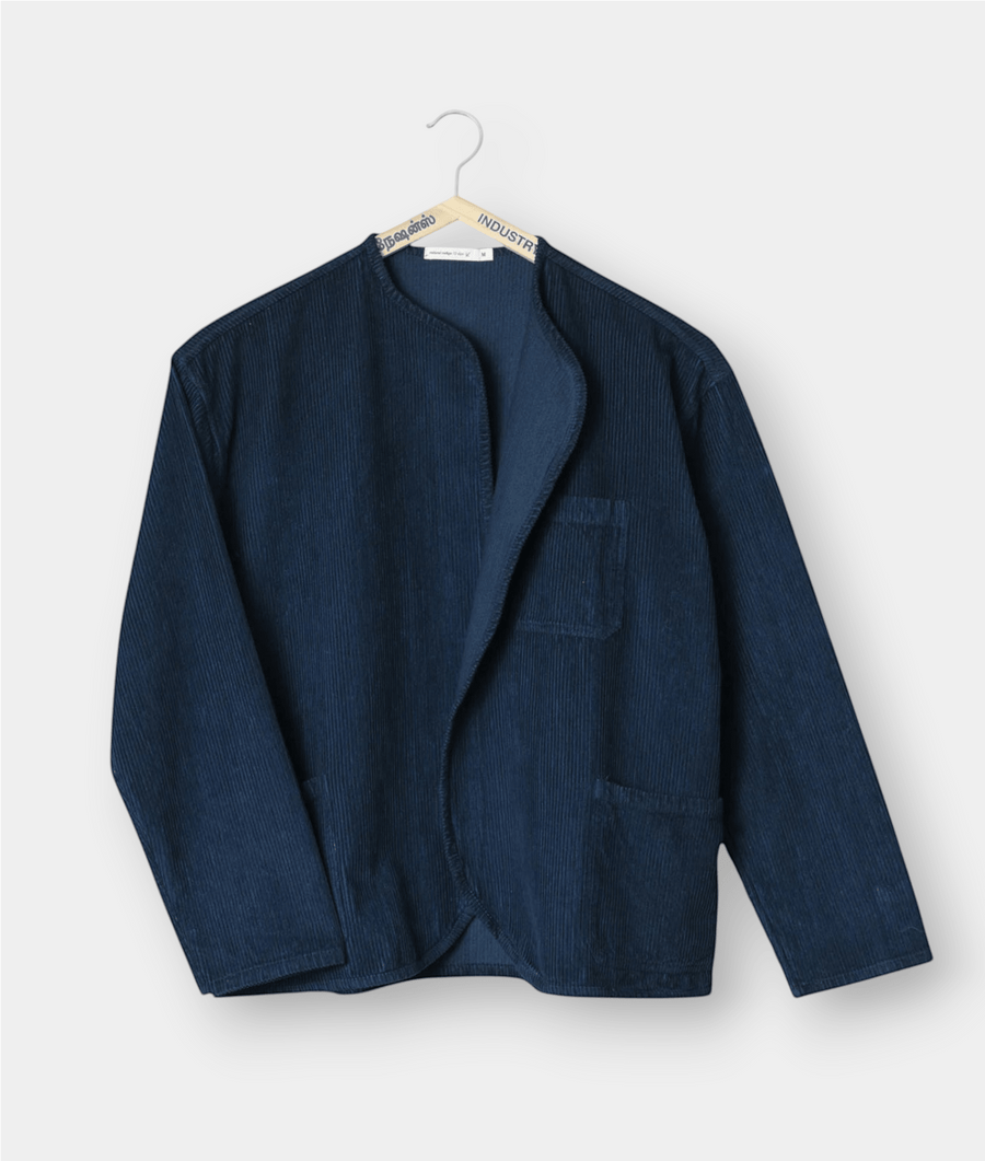 A navy blue corduroy jacket displayed hanging on a hanger - Industry of All Nations