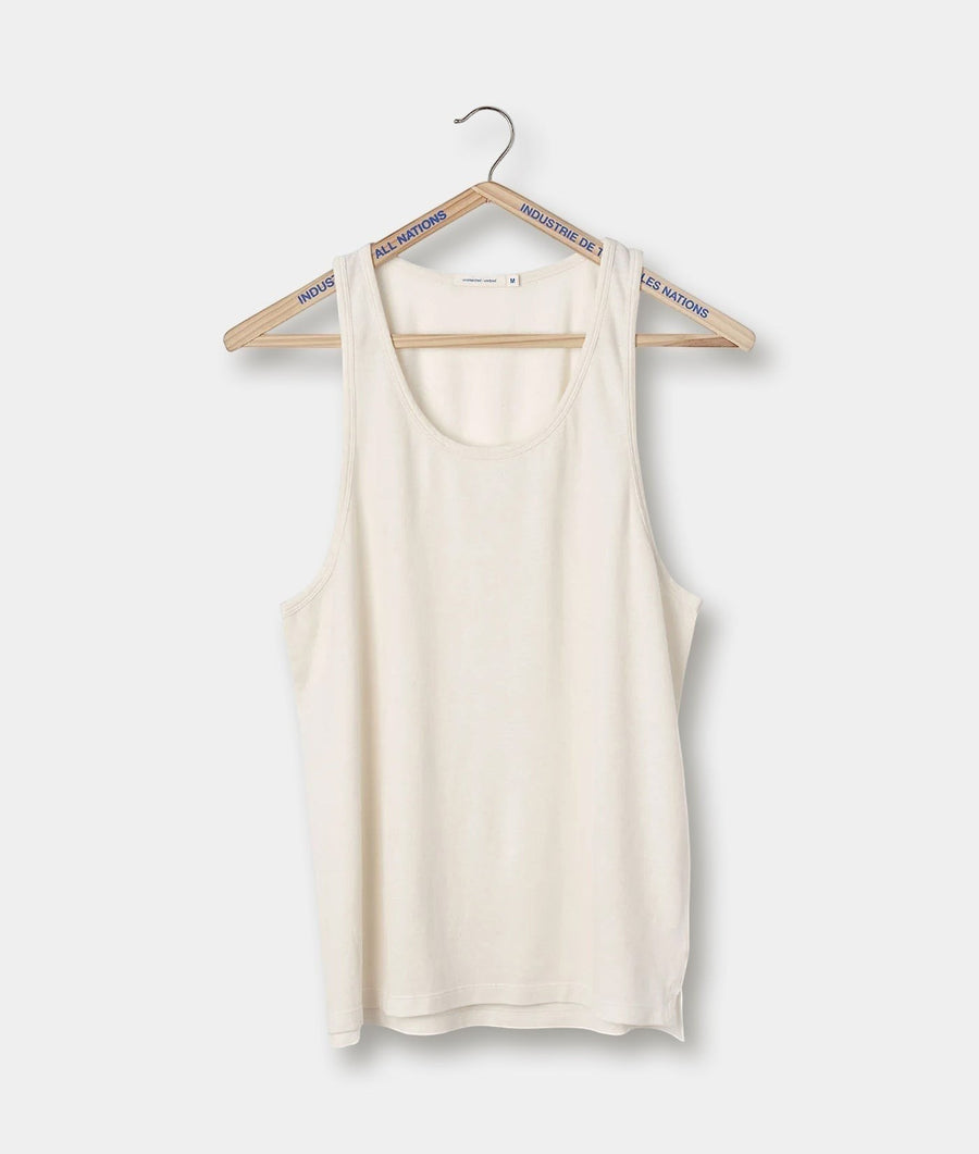 A white, sleeveless racerback tank top hanging on a wooden hanger with the brand name "All Nations" printed along the sides - Industry of All Nations