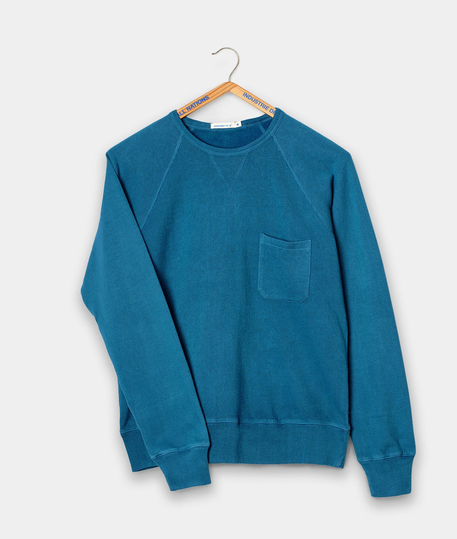Teal blue crewneck sweatshirt with a single front pocket, displayed on a clothing hanger - Industry of All Nations