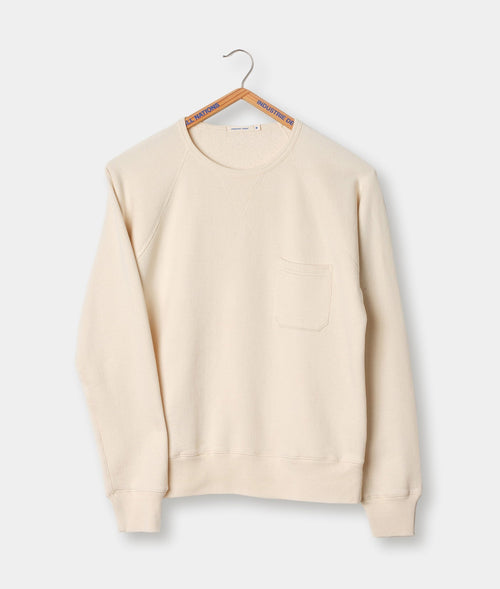 A beige crewneck sweatshirt with a front pocket, displayed on a hanger - Industry of All Nations