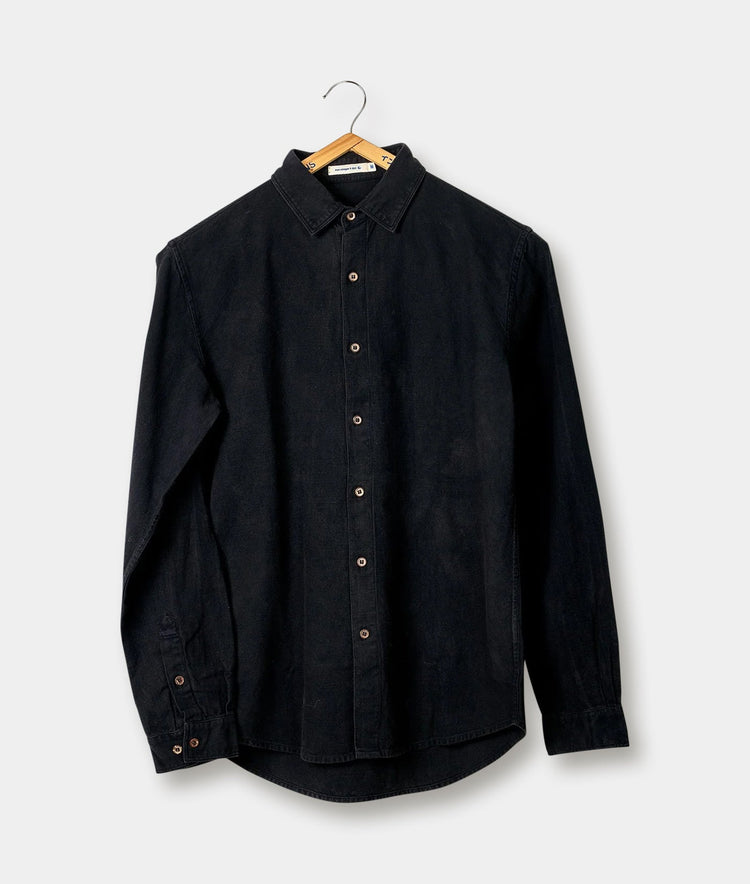 Black denim long-sleeve shirt hanging on a wooden hanger against a plain background - Industry of All Nations