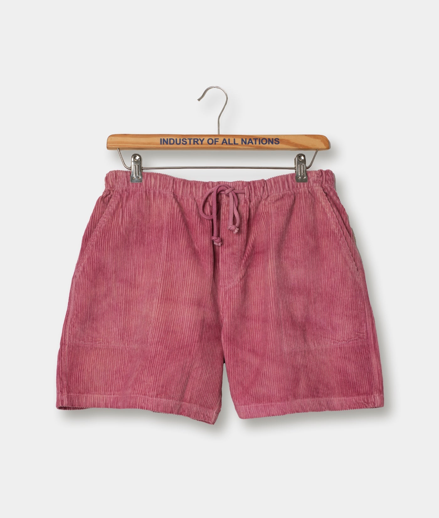 Pink drawstring shorts displayed on a wooden hanger with "Industry of All Nations" text - Industry of All Nations