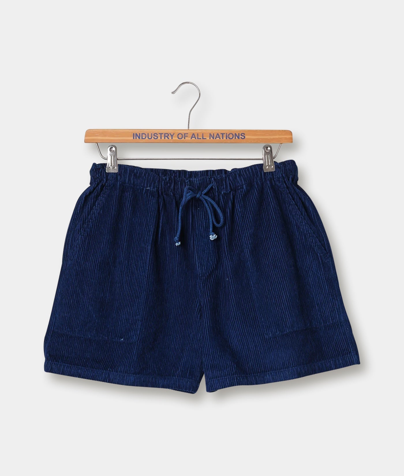 Navy blue corduroy drawstring shorts displayed on a wooden hanger with the brand name 'Industry of All Nations' - Industry of All Nations